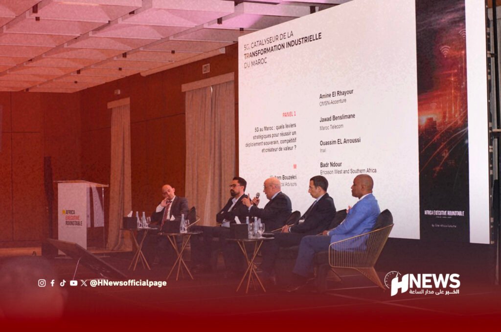 Panel discussion with five men in suits on stage, a large screen behind them and a podium labeled Africa Executive Roundtable.