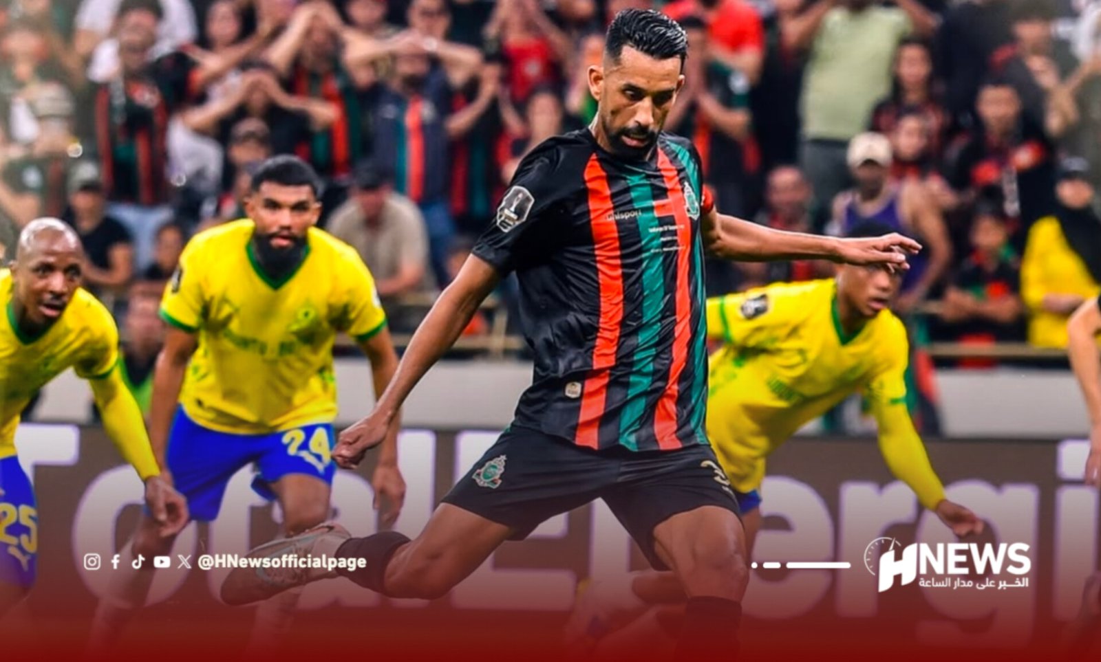 Soccer player in a black jersey with red/green stripes dribbles the ball as yellow-jersey opponents chase, crowd in background.