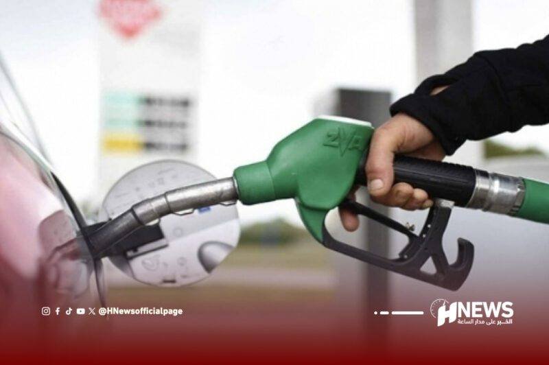 Person refueling a car with a green fuel nozzle at a gas station.