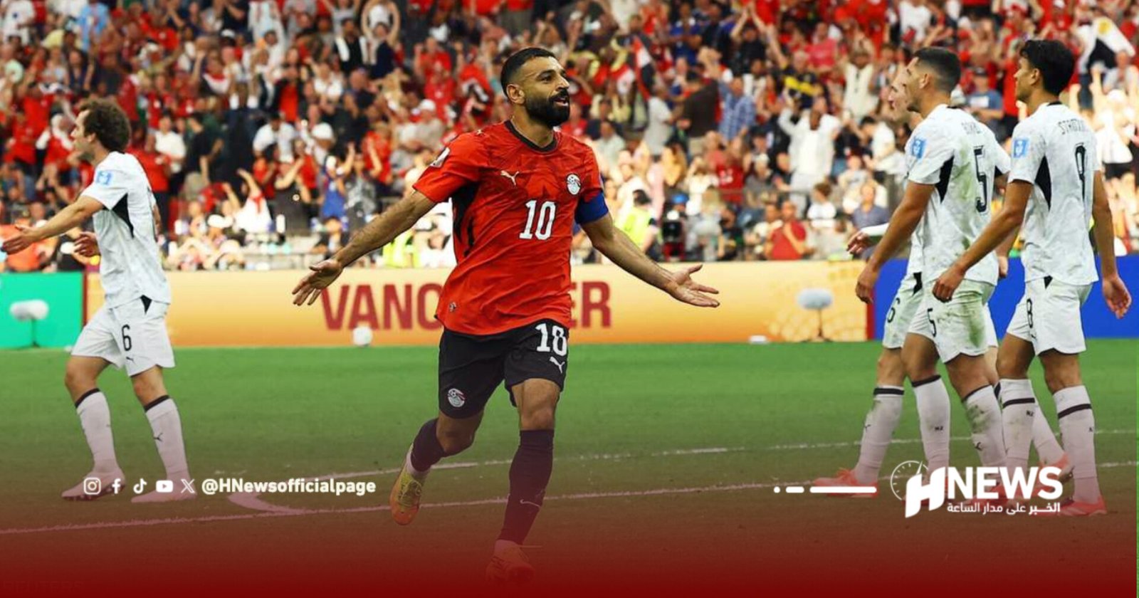 Soccer player in a red jersey (#10) celebrates a goal on the field as fans cheer in the stands.