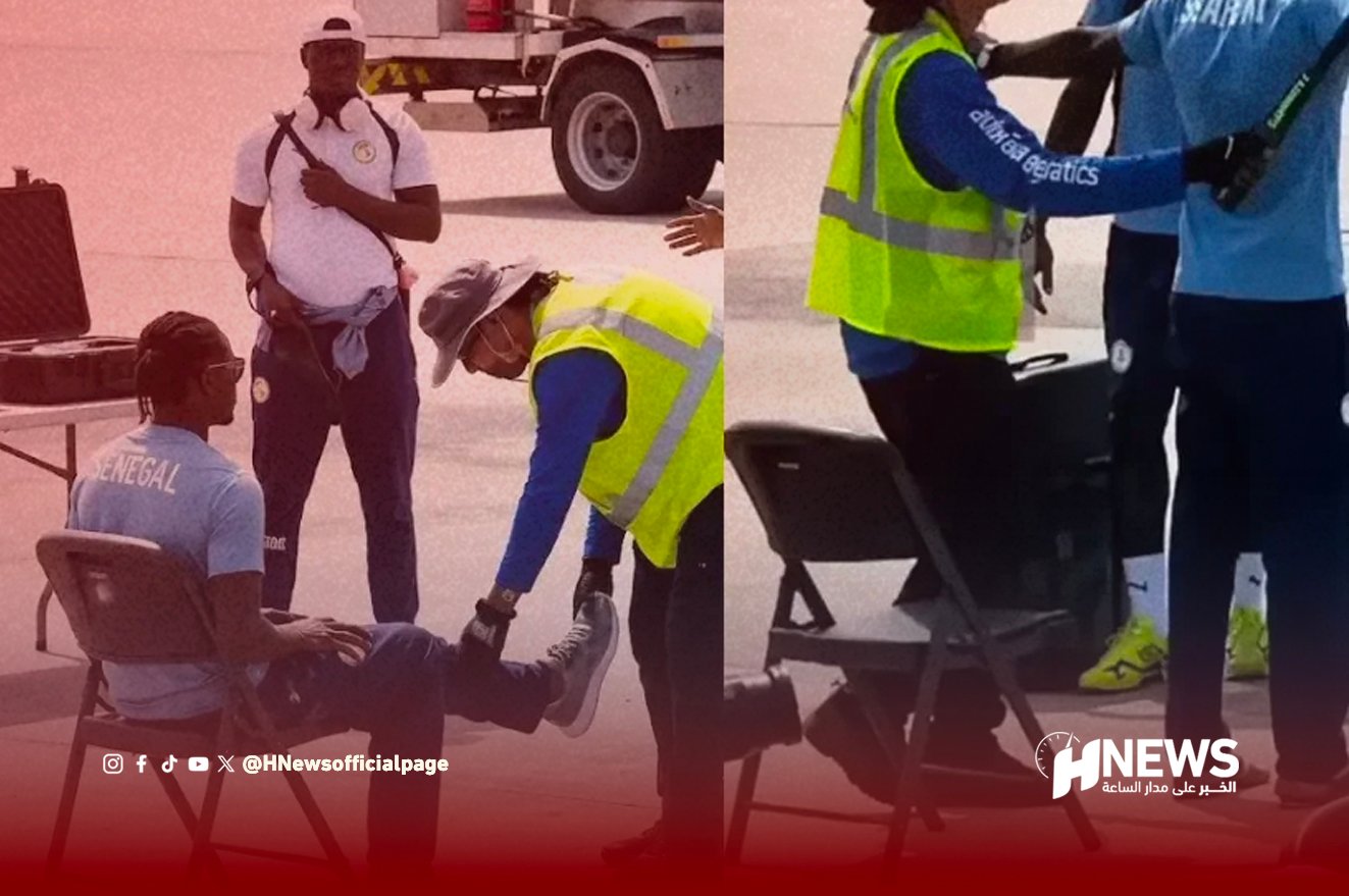 Airport tarmac scene: a seated man being attended to for a leg injury by a responder in a high-visibility vest while others look on.