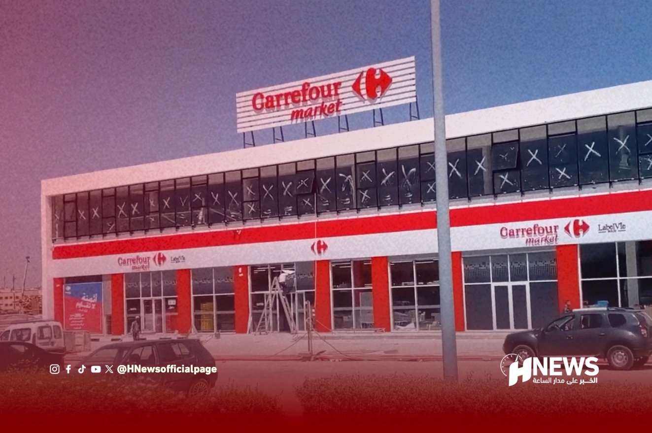 Exterior view of Carrefour Market storefront with red and white facade and large entrance doors, HNews watermark in corner
