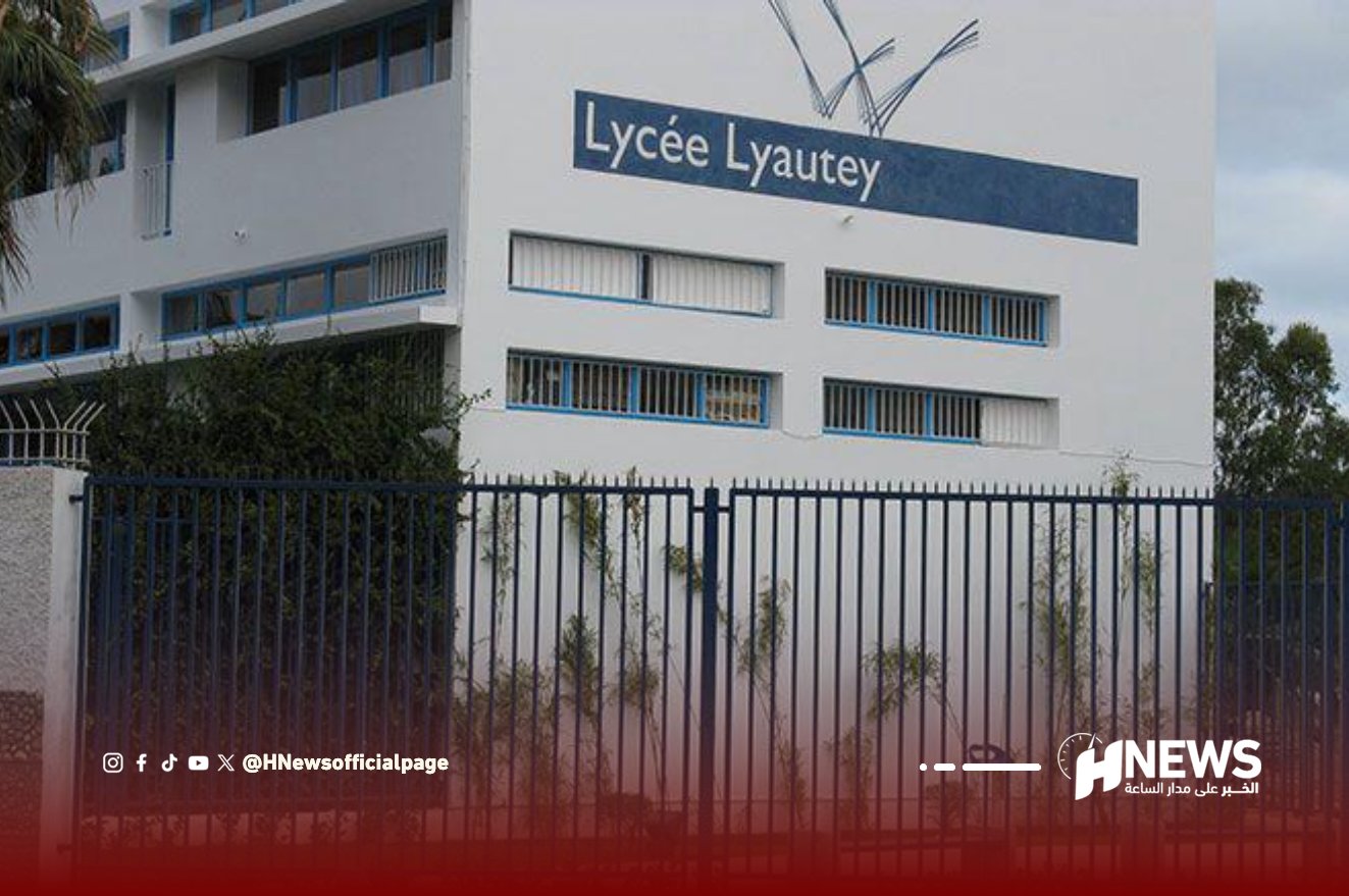 Exterior of Lycée Lyautey, a white multi-story school building with blue window accents, seen behind a tall metal fence.