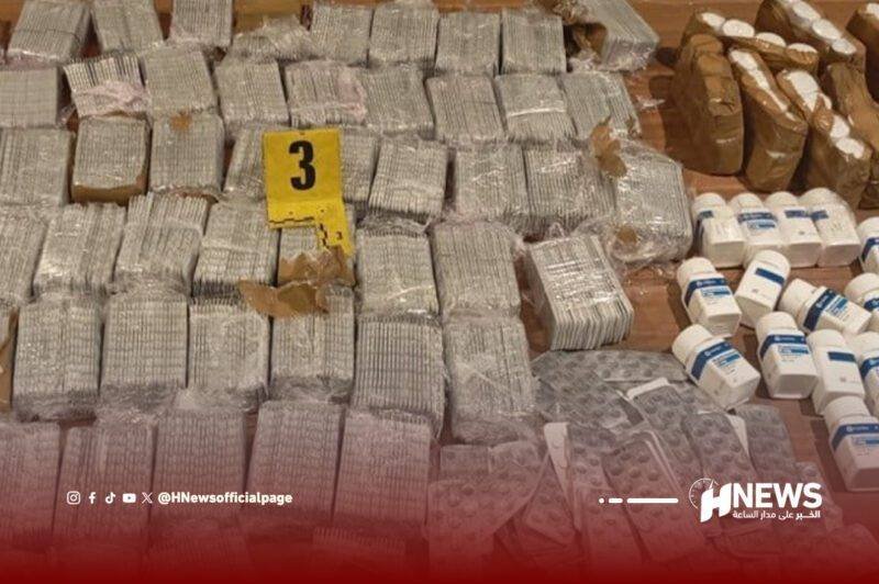 أقراص-مهلوسة-scaled | H-NEWS آش نيوز Pile of sealed rectangular packages with a yellow evidence tag marked '3' in a news photo, plus white bottles on the right; watermarked 'HNews' at bottom.