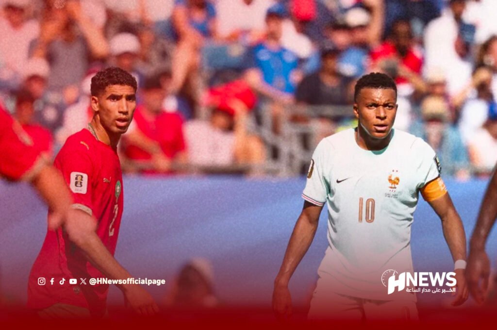 Two soccer players on a pitch during a match, one in a red jersey left and the other in a white jersey with number 10 and a captain's armband on the right, with a crowded stadium in the background and a news watermark in the corner