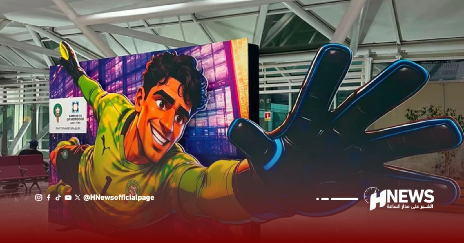 Colorful mural of a smiling soccer goalkeeper reaching toward the viewer in a bright yellow jersey, indoors with a glass-ceiling atrium and HNews branding visible in the corner.