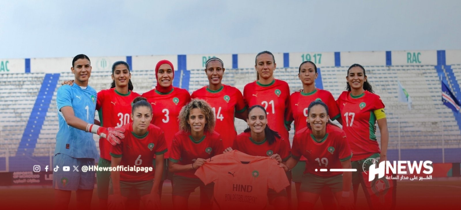 Moroccan women's soccer team posing for a group photo on the field, red uniforms with green trim and a blue goalkeeper in the background.