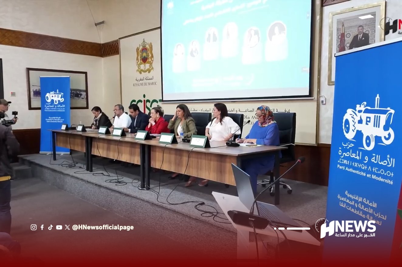 منتدى المرأة البامية | H-NEWS آش نيوز Panel of seven officials seated at a long conference table with microphones during a press briefing, projector screen behind them.