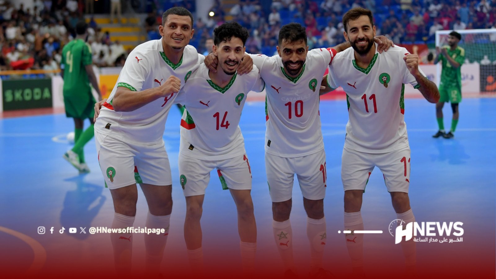 Four teammates in white uniforms with green trim stand together on a blue futsal court, arms around each other and smiling after a match.